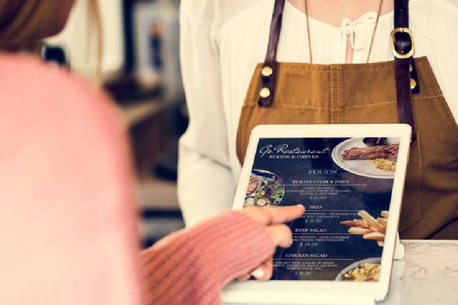 Customer ordering food at restaurant counter.