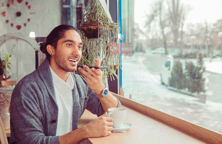 A man talking over the phone inside a restaurant.