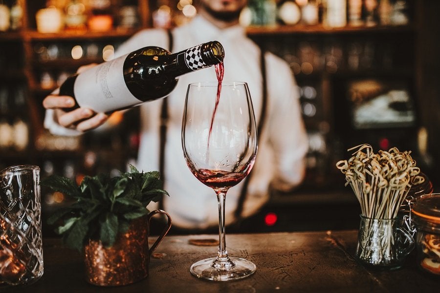 Waiter serving wine on a glass.