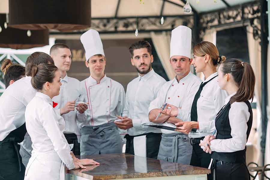 Restaurant manager and his staff in terrace having a meeting.