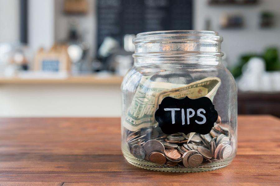 Glass jar with coins and inscription tips.