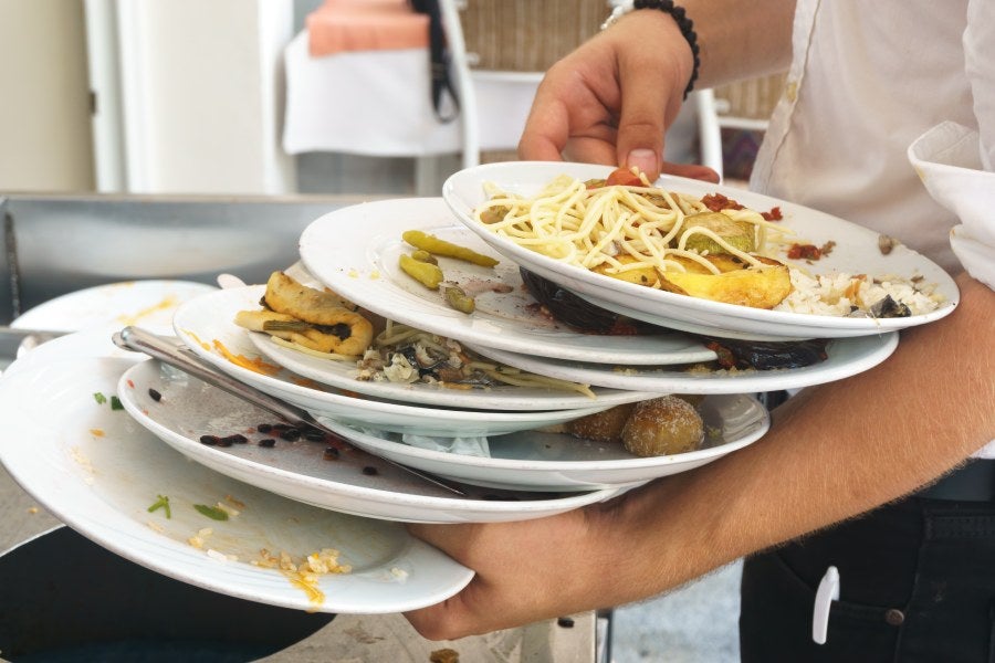 A picture of plates with leftover food waste carried by chef.