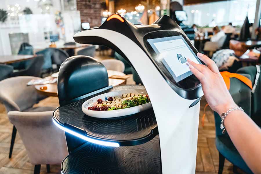 Robot waiter serve food at modern restaurant table.Offering innovation futuristic high-tech automated dining experience.