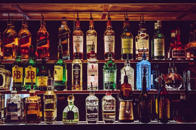 Assorted liquor bottles behind a bar