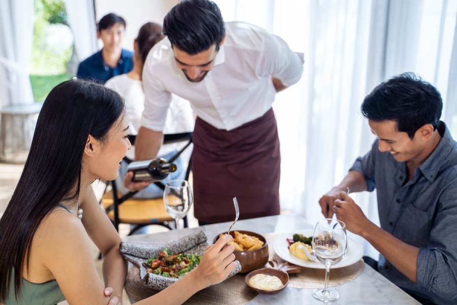 Caucasian waiter receiving order serving from customer in restaurant.