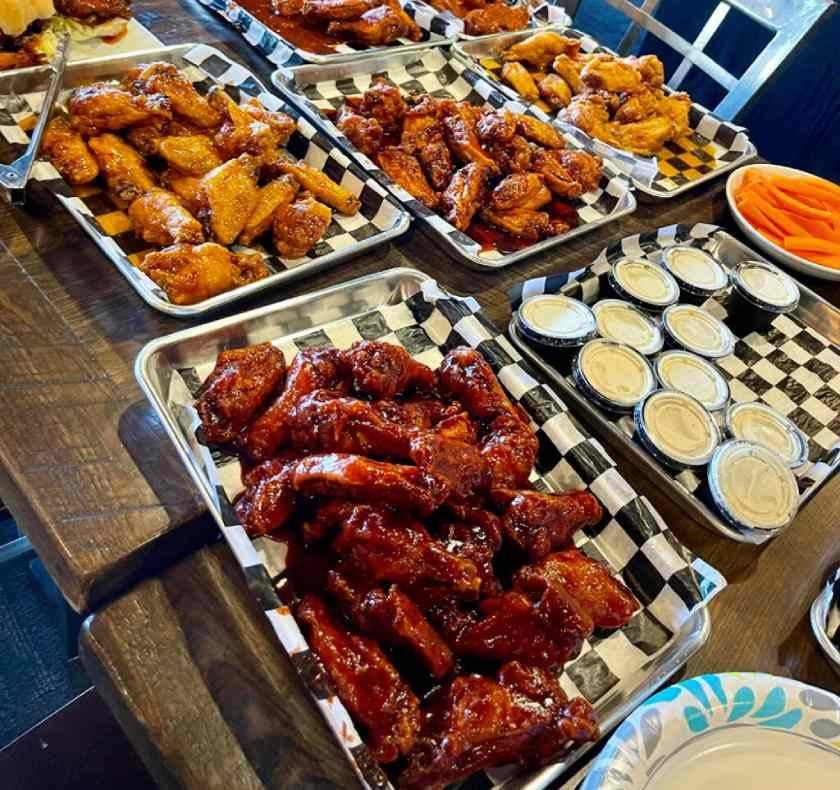 Photo of chicken wings and sauce in a cup.