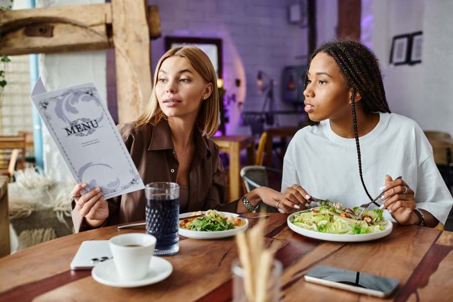 Friends enjoying a cozy cafe meal together, smiling and sharing moments.