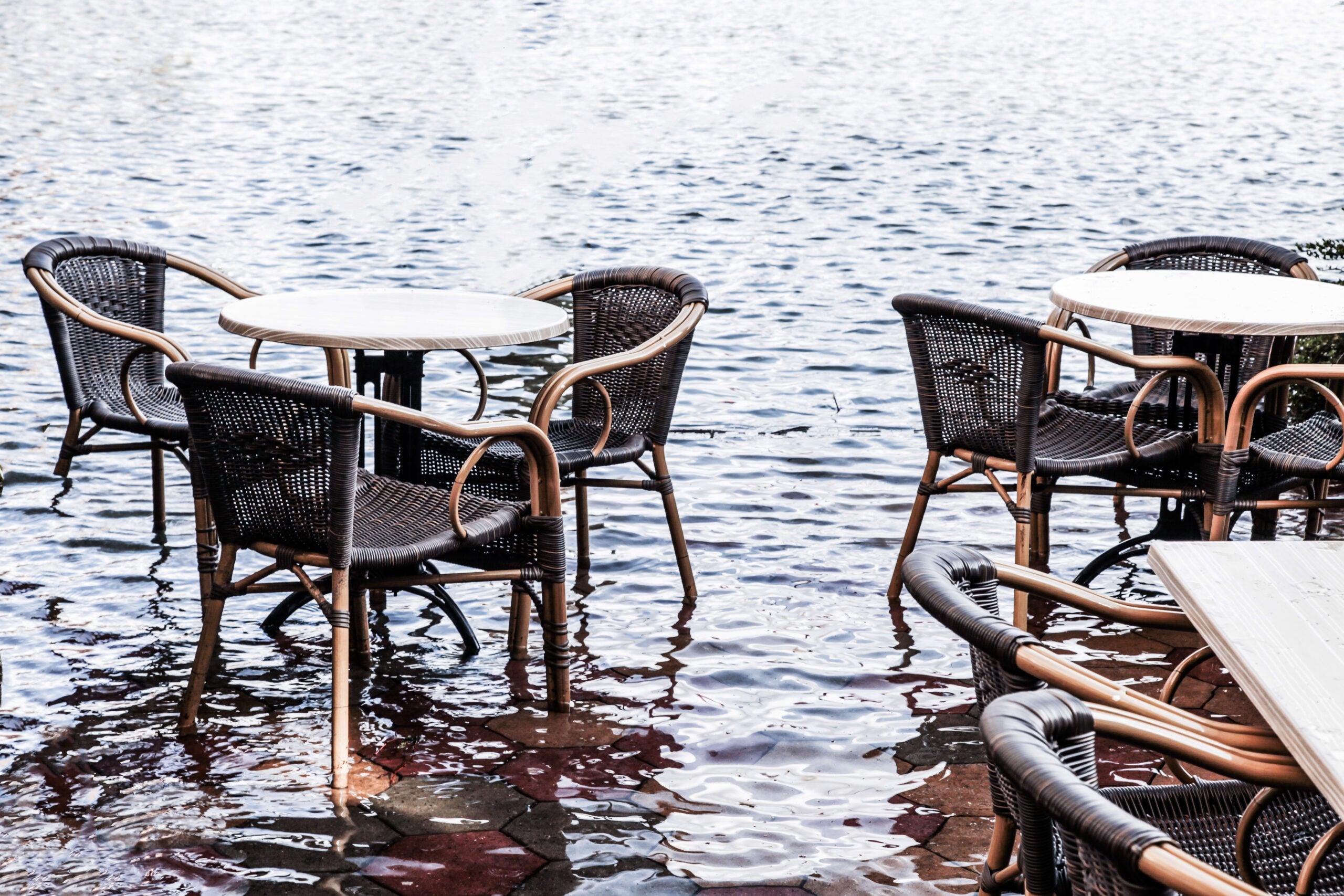 Patio chairs and tables on a flooded cafe patio