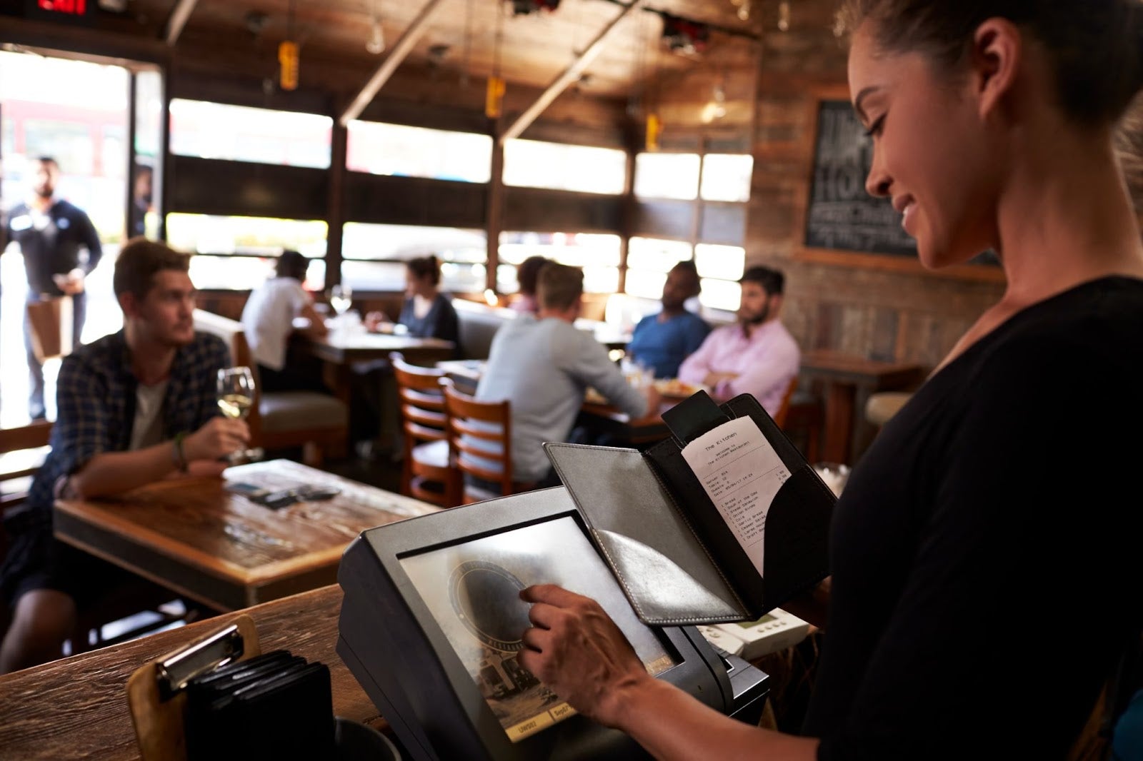 Server entering order on a touchscreen POS