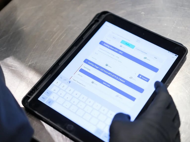 A user holding a tablet with the SafetyCulture food safety software on the screen.